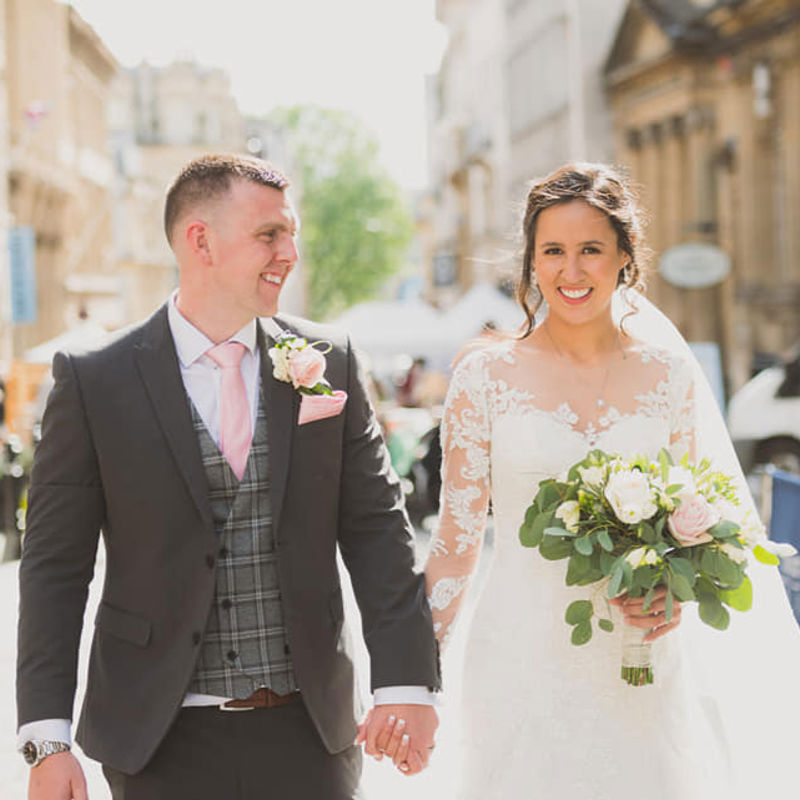 Bride laughing with bridesmaids in pink dresses